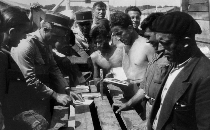 "El oficial de los gendarmes rompe los diarios de ideas liberales que llegan por correo. ¿Es posible que esto pase en Francia?". © Ministerio de Cultura de España. Centro Documental de la Memoria Histórica. Fondo Histórico Agustí Centelles i Ossó. ["Esta fotografía se suministra exclusivamente para la información cultural de la exposición, no se puede almacenar en forma alguna ni ceder a terceros"].