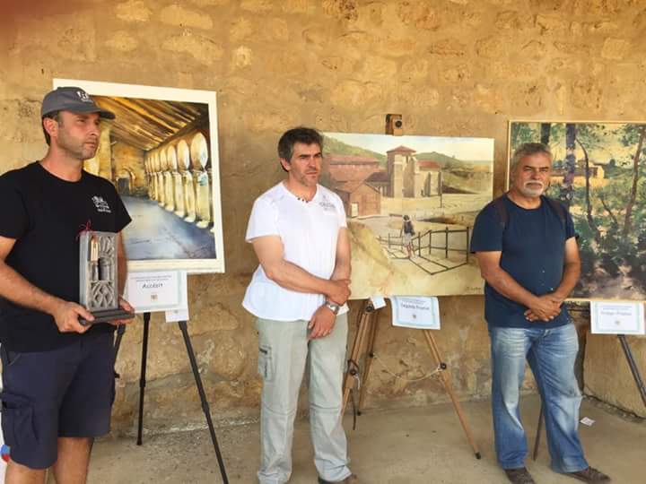 Los artistas ganadores, delante de sus obras.